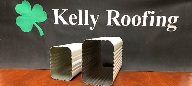 Kelly Roofing display featuring square metal downspout options used for residential gutter and drainage systems