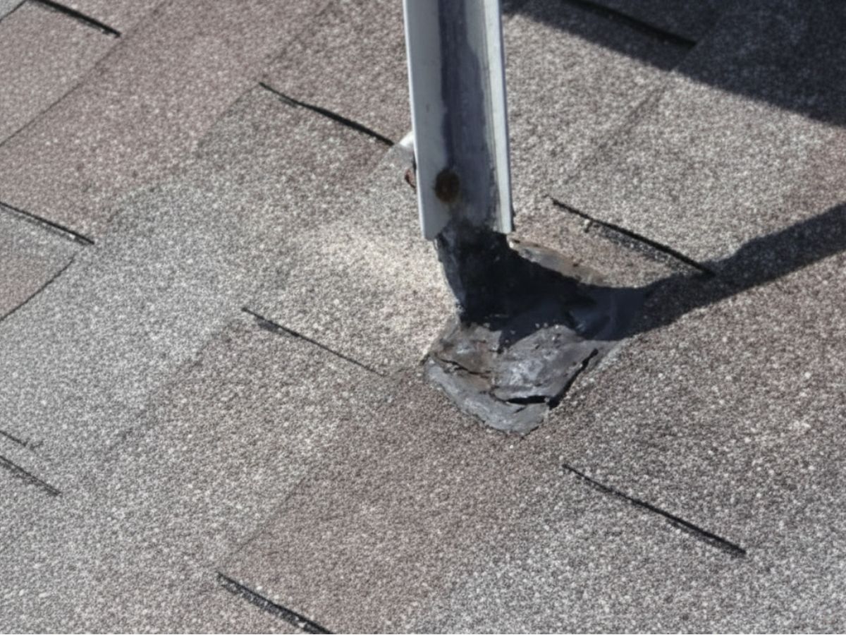 Damaged sealant around roof penetration on asphalt shingles
