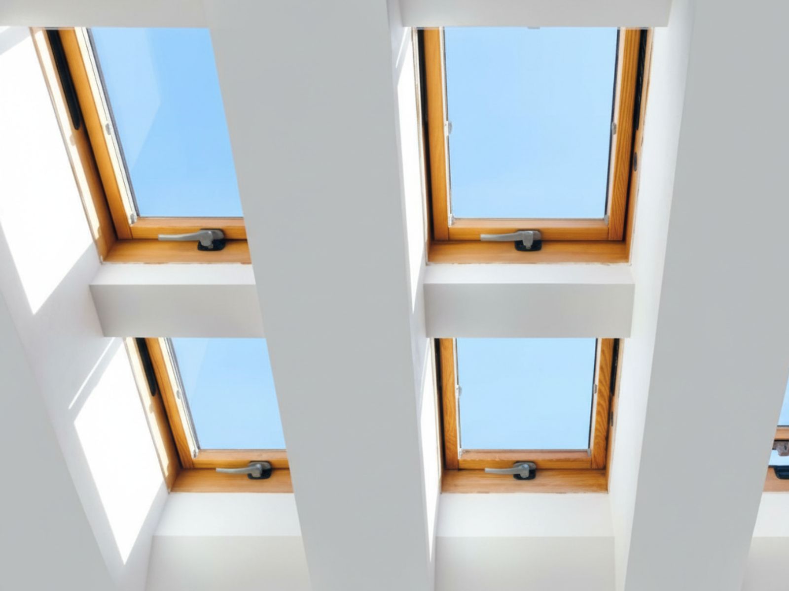 Interior view of multiple skylight windows allowing natural light into a modern home attic or loft space